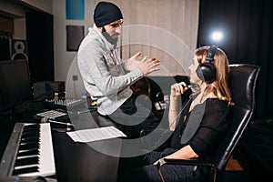 Sound producer with female singer in music studio