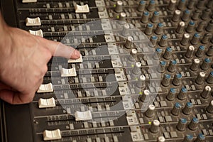 Sound producer moving fader of dusty sound mixer