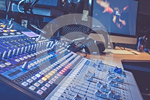 Sound recording studio mixer desk: professional music production, equipment in the blurry background