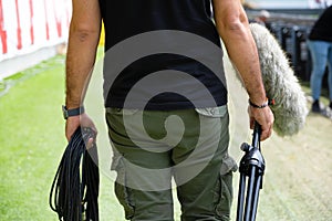 A sound technician is placing a shotgun microphone