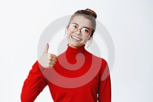 Sounds good, nice work. Smiling female entrepreneur in glasses showing thumb up, approve and like good thing, praise