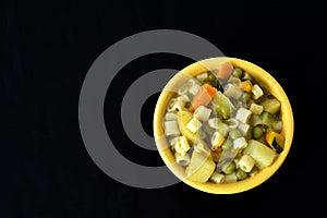 Soup bowl with pasta, beans and vegetables on black background