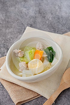 Soup with egg tofu and minced pork in a white oval cup