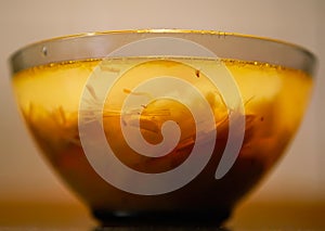 The soup is in a glass transparent bowl. Close-up.