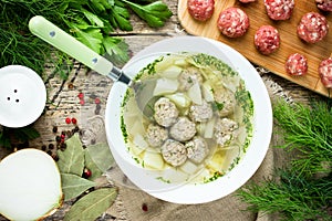 Soup with meatballs noodles potato greens and spices in white bo