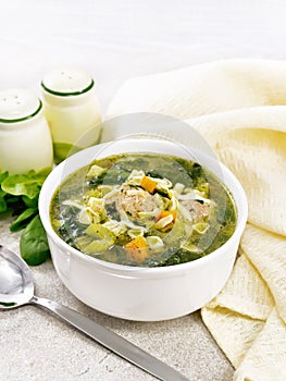 Soup with meatballs and pasta in bowl on stone counter