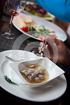 Soup with meatballs in a white porcelain dish