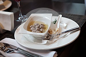 Soup with meatballs in a white porcelain dish