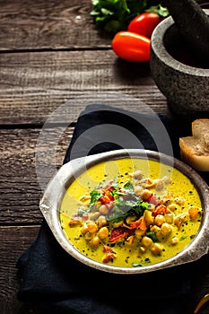 Soup in mug with chick-pea and spices ondark wooden background. photo