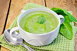 Soup puree with spinach leaves on board