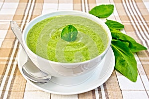 Soup puree with spinach and spoon in bowl