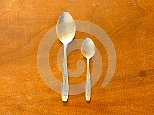Soup Spoon and Dessert Spoon On Wooden Table