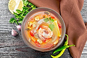 Soup Tom Yum with lemons in bowl on dark board top