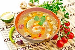 Soup Tom Yum with lime in bowl on white board