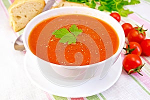 Soup tomato in bowl on linen napkin