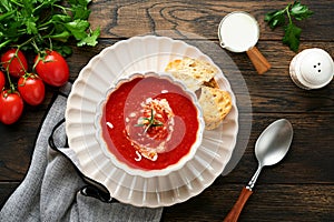 Soup. Tomato cream soup or gazpacho with herbs, seasonings, cherry tomato and parsley in white bowl on dark wooden old background