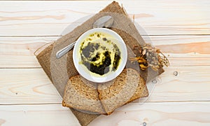 Soup with yogurt on light color wooden background.