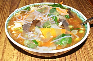 Soupy noodles with green vegetables & cheese slices photo