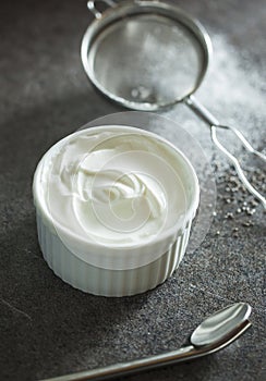 Sour cream with strainer and spoon