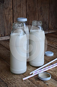 Sour-dairy drink or yoghurt in bottle that come from the kefir grains and milk on wooden background. Photographed with natural lig
