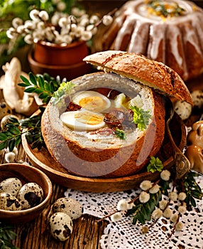 The Sour soup made of rye flour with sausage and eggs served in bread bowl. Traditional easter polish sour rye soup