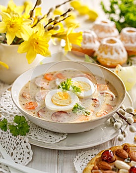 The sour soup ÃÂ ÃÂ»urek, polish Easter soup with the addition of sausage, hard boiled egg and vegetables in a ceramic bowl