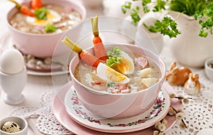 The sour soup ÃÂ»urek, polish Easter soup with the addition of sausage, hard boiled egg and vegetables in a ceramic bowl.