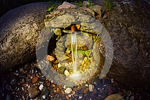 The source of natural water, wellspring, flowing through rocks in forest