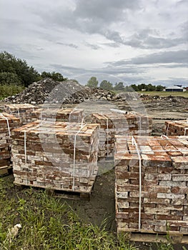 Sourcing red brick from demolition. Stacks of bricks prepared for sale