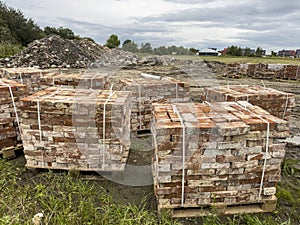 Sourcing red brick from demolition. Stacks of bricks prepared for sale photo