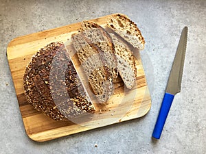 Sourdough artisanal bread loaf and slices on wooden cutting board