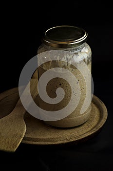 sourdough for baking bread  with wooden spoon and rolling pin