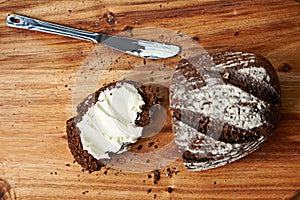 Sourdough, bread and butter on slice for meal, nutrition and carbs on kitchen table or fibre. Top view, wheat and rye