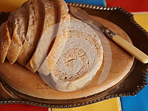 Sourdough bread on cutting board with butter knife