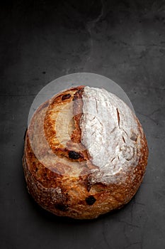 Sourdough bread with mixed fruits and nuts on dark cement background.
