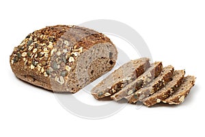 Sourdough loaf of bread and slices with a variation of seeds close up on white background