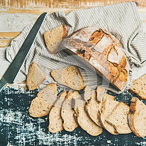 Sourdough wheat bread cut in slices on table, square crop