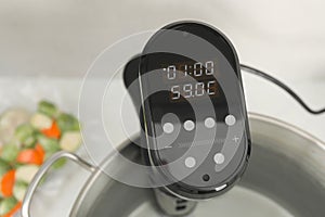 Sous vide cooker in pot on table, closeup. Thermal immersion circulator