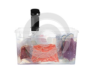 Sous vide cooker and vacuum packed food products in box isolated on white. Thermal immersion circulator