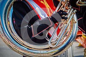 Sousaphone circling uniformed student marchers shoulder as he plays the instrument in a parade - close-up