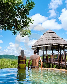 South Africa, luxury safari lodge in the bush of a Game reserve, couple by swimmingpool