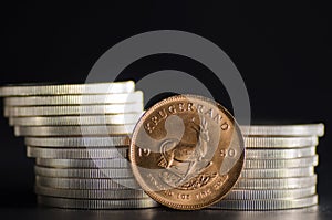 South African Gold Coin Krugerrand infront of Silver Coins