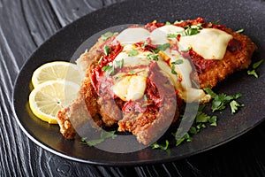 South American food: Milanesa napolitana Beef cutlet in breadcrumbs with mozzarella cheese and tomato sauce close-up. horizontal photo