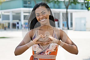 South american woman with tradtional clothes showing heart with fingers photo