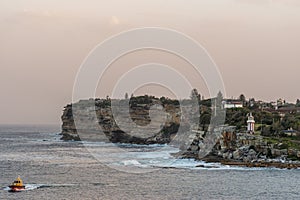 South Head cliffs, crashing waves, boat and Tasman sea gate, Sydney Australia