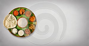 South india meals, meals served on banana leaf brass plate , traditional south indian cuisine, rice, sambar, rasma, appalam, white