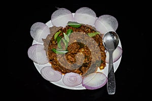 South Indian cuisine Kerala Style Beef fry / roast. Traditional style meat roast. Garnished with onion slices and curry leaves.
