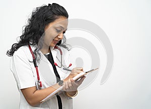 A south Indian female doctor in 30s writing medical prescription advice on a board with pen with white coat and red