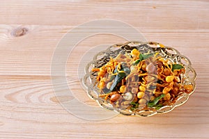 South indian spicy crunchy mix Nimco or Namkeen with peanut, rice, curry leaves and spice golden bowl background isolated