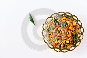 South indian spicy crunchy mix Nimco or Namkeen with peanut, rice, curry leaves and spice golden bowl background isolated top view